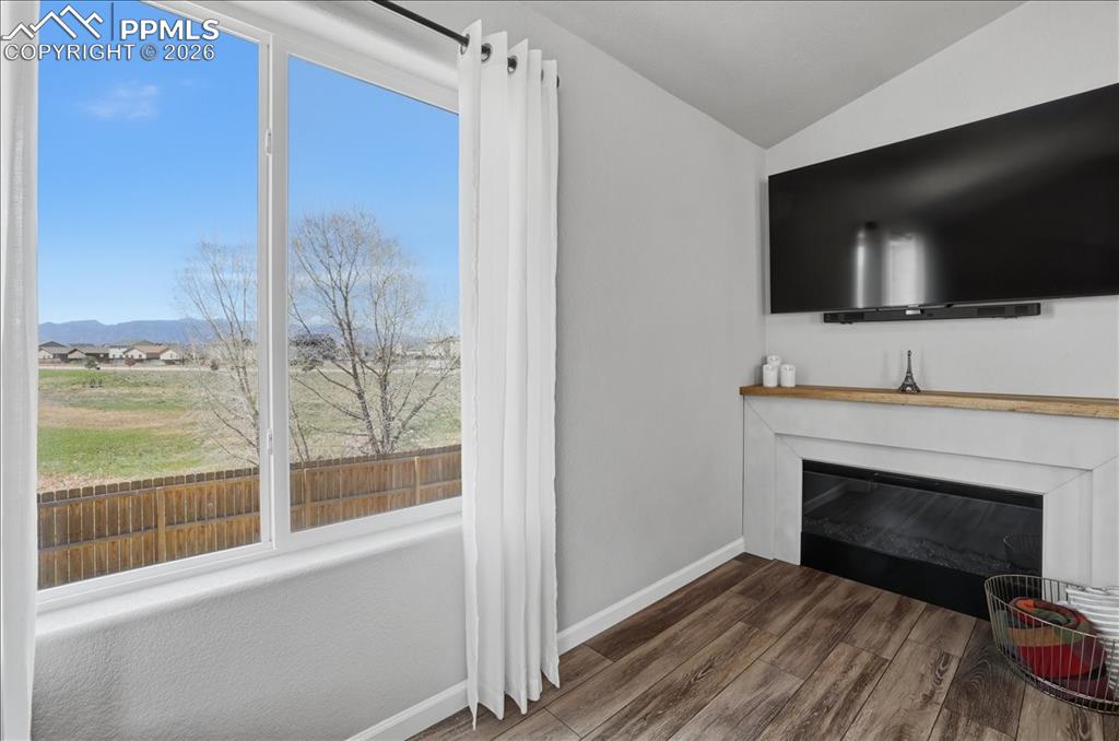 Image 6 of 47: Living area featuring a fireplace with a light wood mantle, wood-style floo