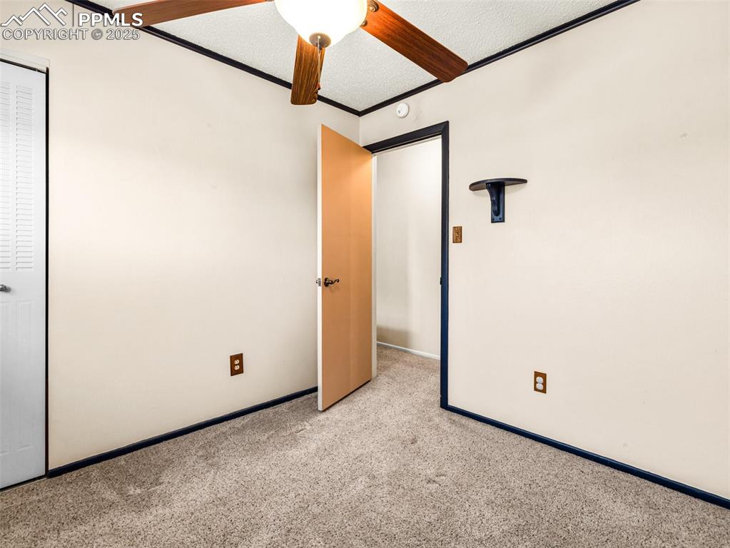 Image 15 of 38: Unfurnished bedroom with carpet, a textured ceiling, and crown molding