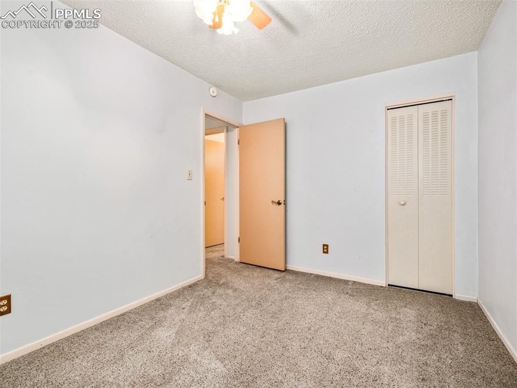 Image 17 of 38: Unfurnished bedroom with carpet flooring, a textured ceiling, a closet, and