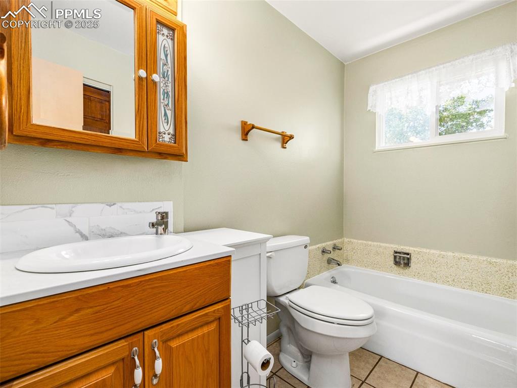 Image 20 of 38: Full bath featuring a bath, vanity, and light tile patterned floors