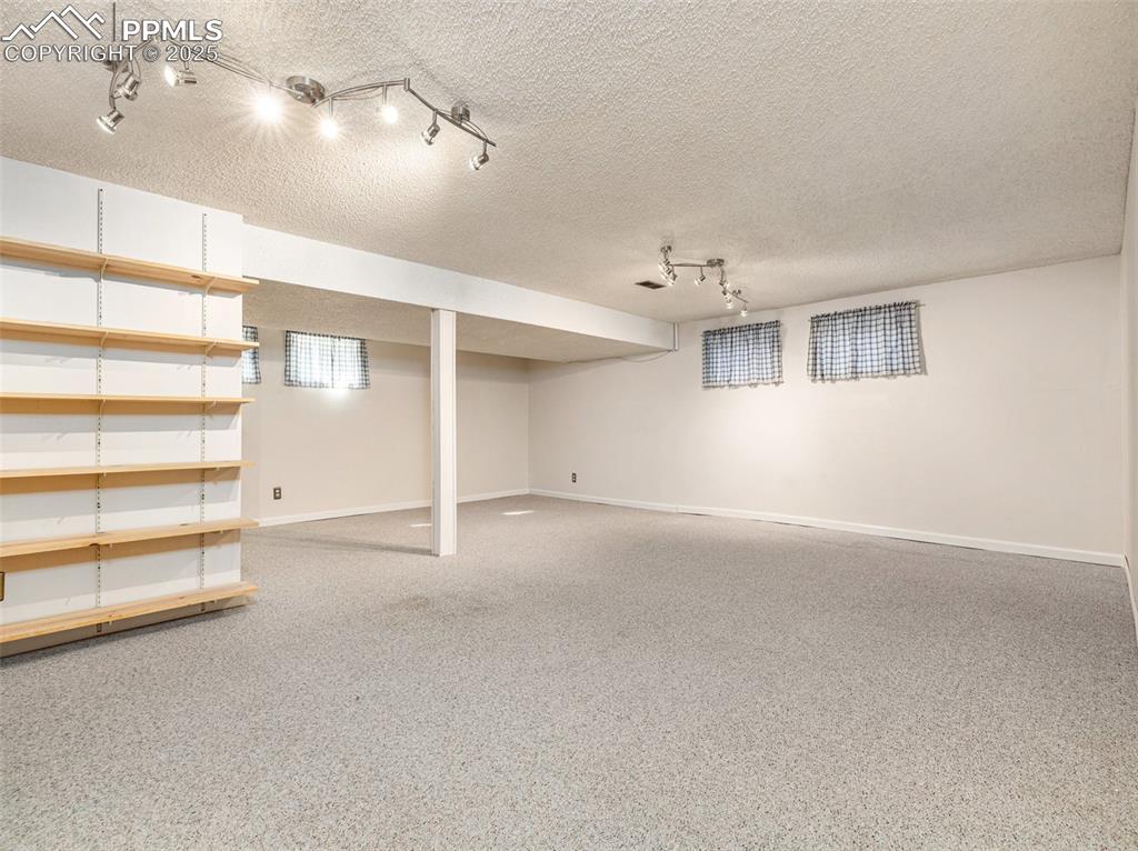 Image 26 of 38: Finished below grade area featuring a textured ceiling, light carpet, and t