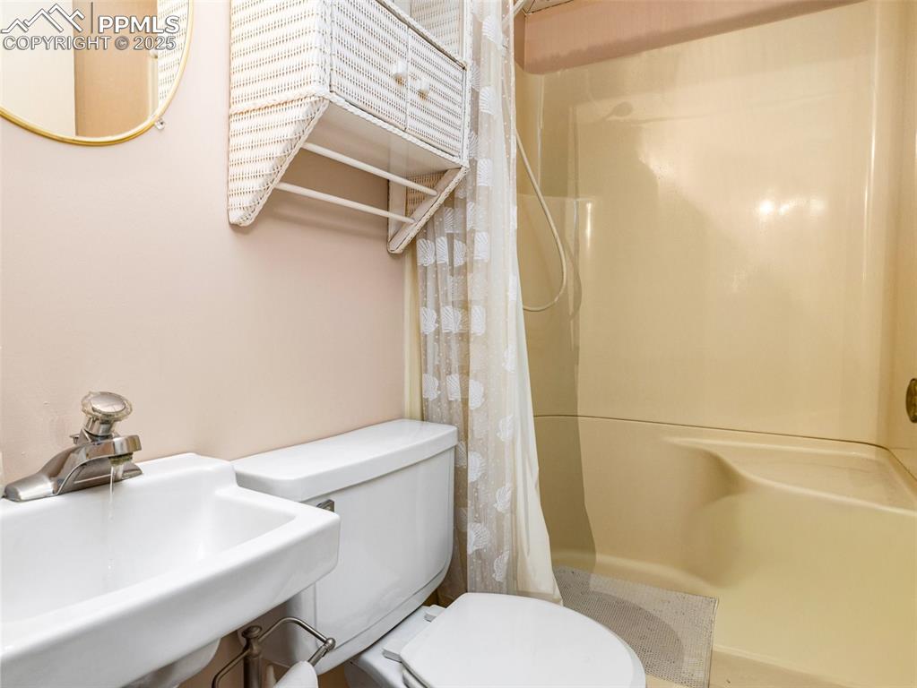 Image 30 of 38: Bathroom featuring a sink and a stall shower