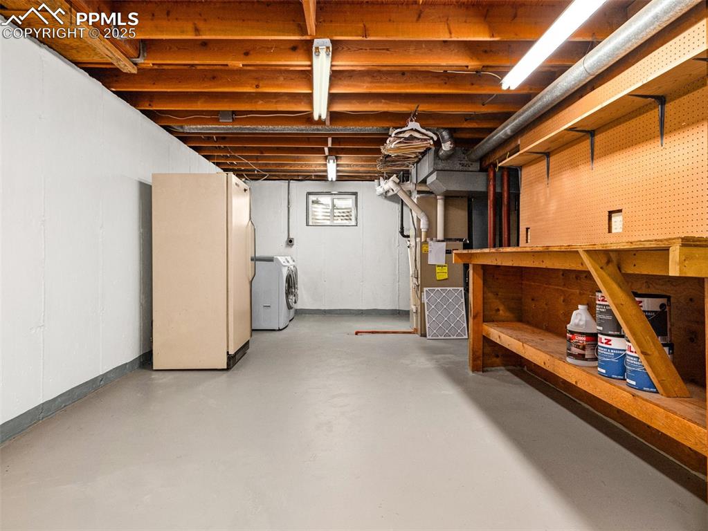 Image 31 of 38: Basement with freestanding refrigerator and heating unit,