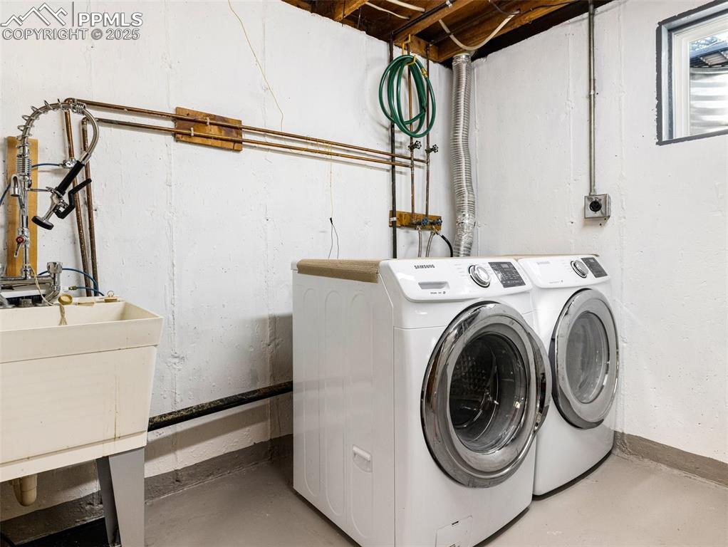 Image 32 of 38: Laundry room with independent washer and dryer and baseboards