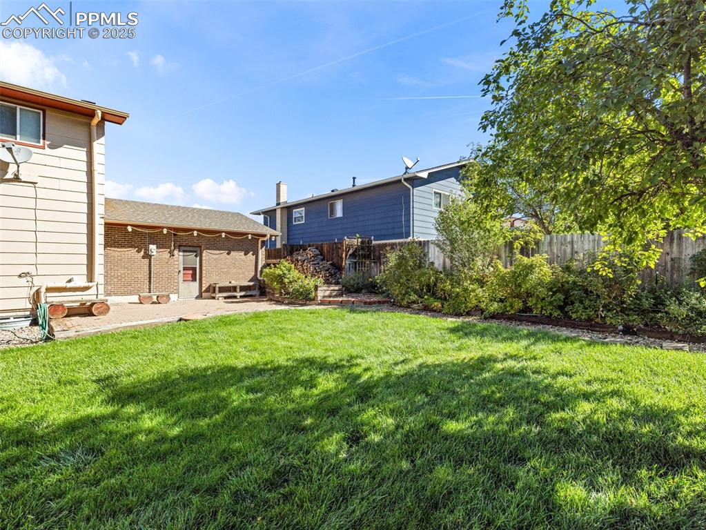 Image 36 of 38: Fenced backyard with a patio