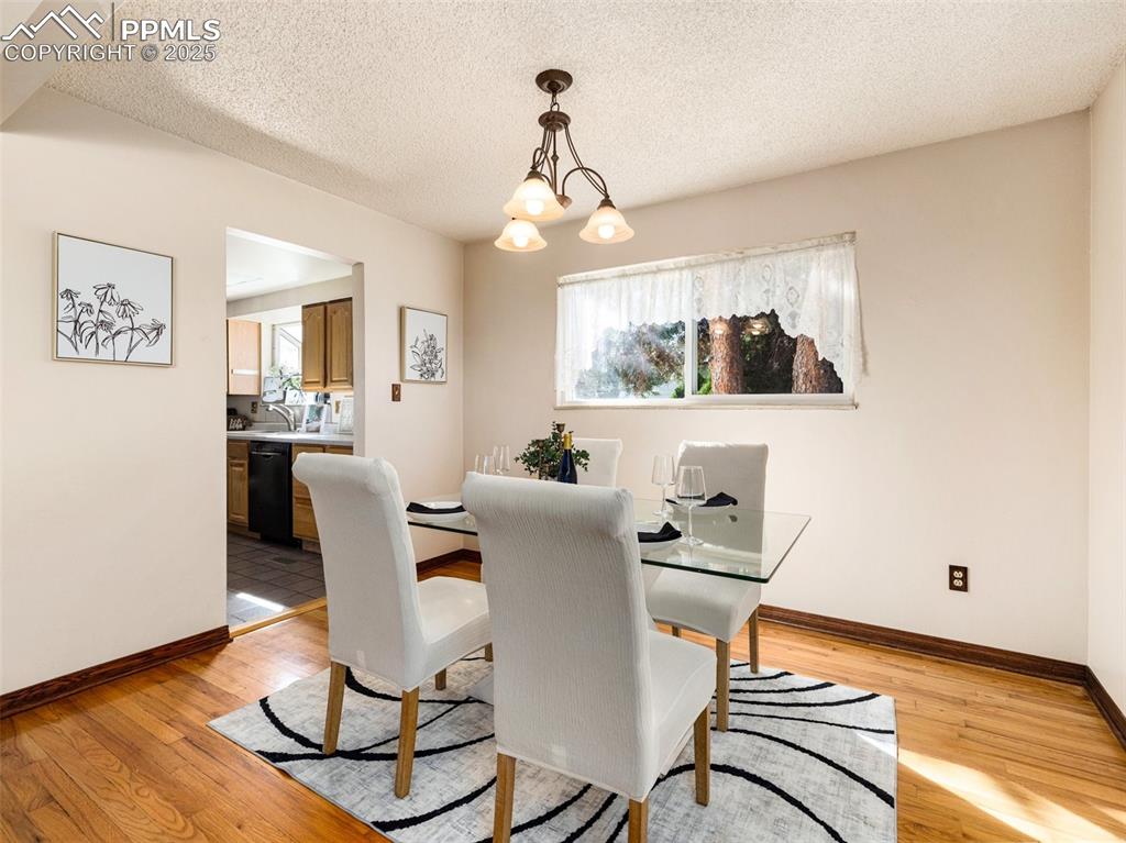 Image 4 of 38: Dining area featuring plenty of natural light, a textured ceiling, light wo