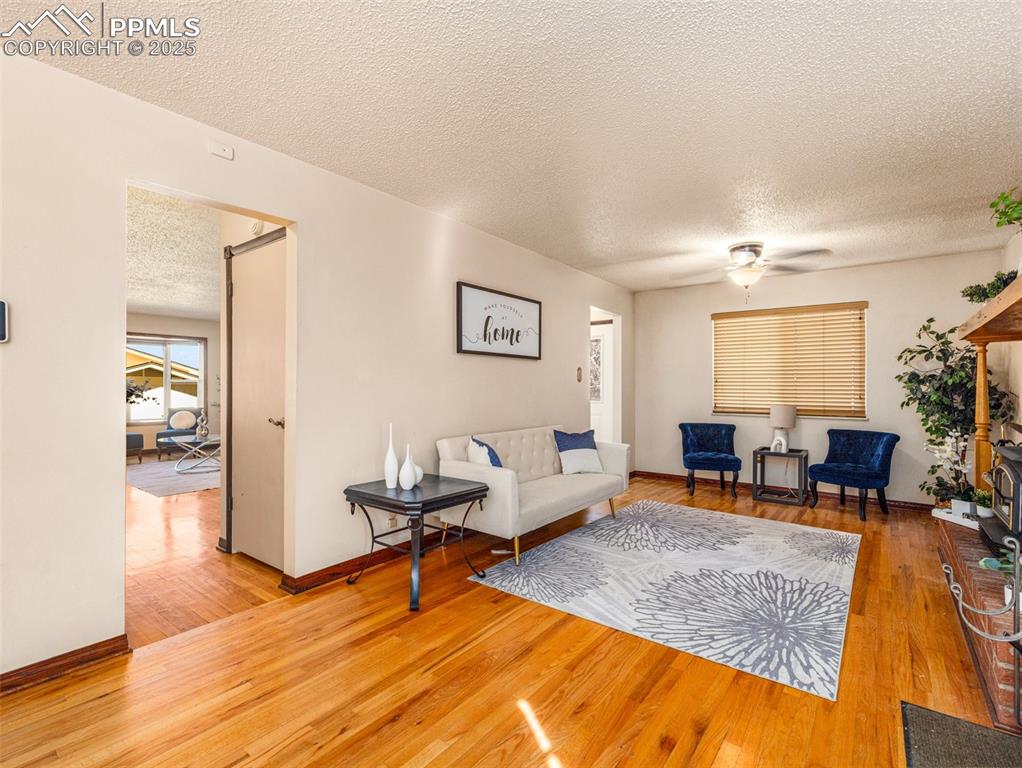 Image 9 of 38: Living room with a textured ceiling, light wood-style flooring, and a ceili
