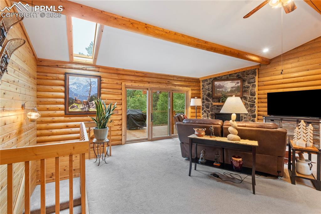 Image 12 of 46: beamed ceilings, ceiling fan & skylights occupy the upper spaces of this li