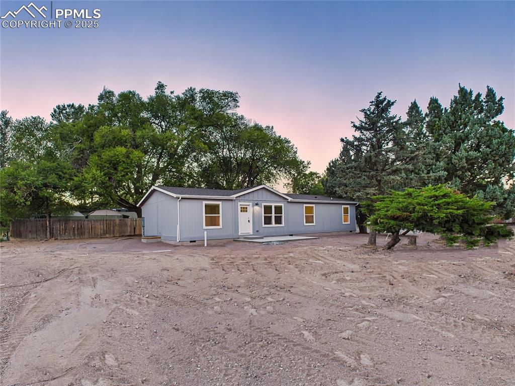 Caption: Level 0.23-acre lot with mature trees around the perimeter offering shade and privacy.