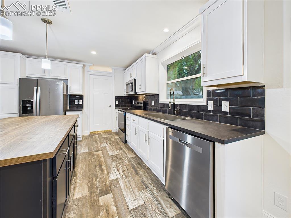 Image 18 of 50: Stainless steel appliances, pendant lighting add both function and style.