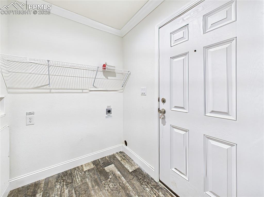 Image 45 of 50: Dedicated laundry space with washer/dryer hookups and overhead shelving.  C