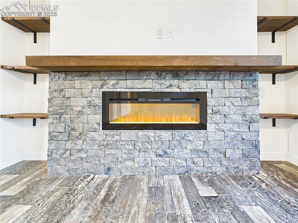 Image 9 of 50: Close up of modern linear electric fireplace set in a stacked-stone surroun