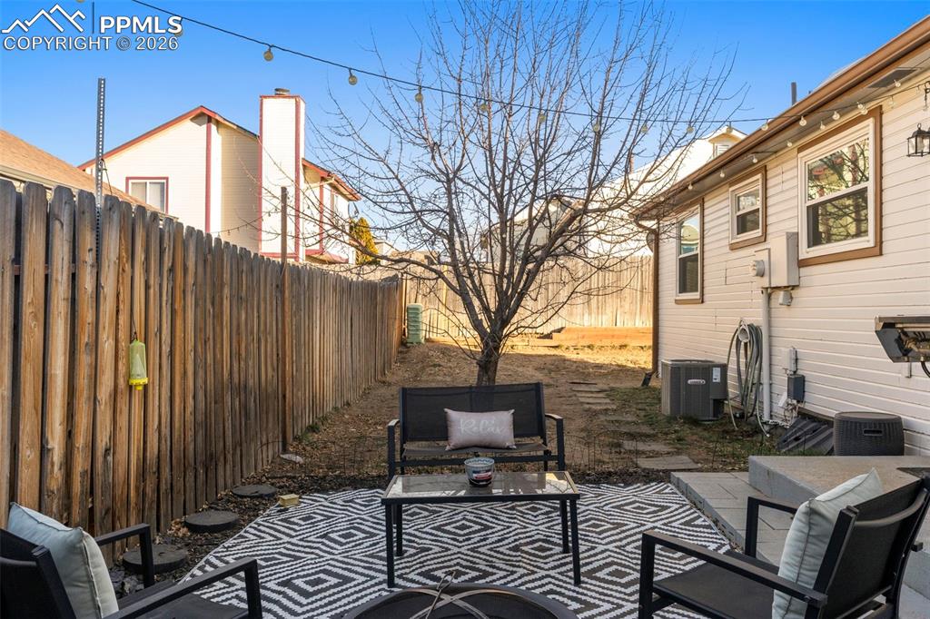 Image 26 of 29: Fenced backyard with a patio area and an outdoor living space