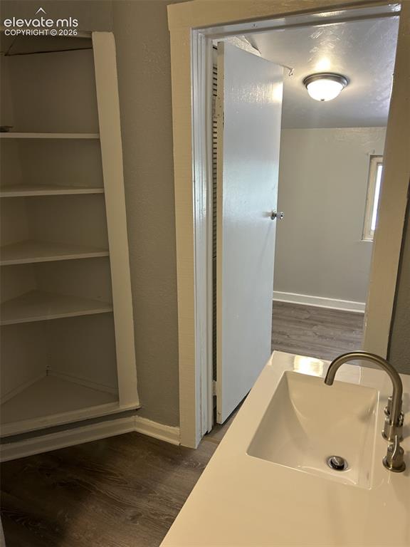 Image 38 of 45: Built-in shelving, wood-finish flooring, integrated sink with a brushed nic