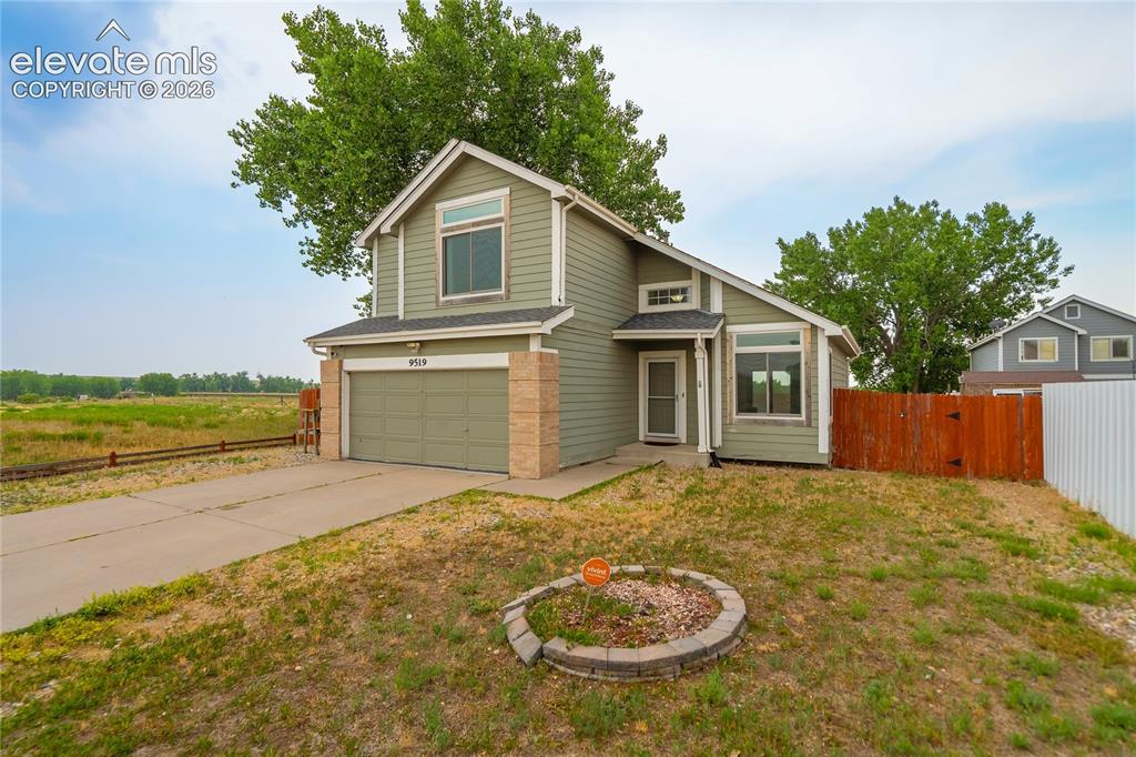 Image 1 of 40: Two-story residence with light green siding and an attached garage