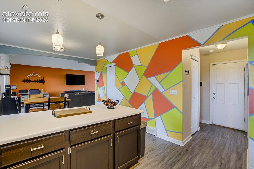 Image 14 of 40: Kitchen island with dark wood-finish cabinetry and a light-toned countertop