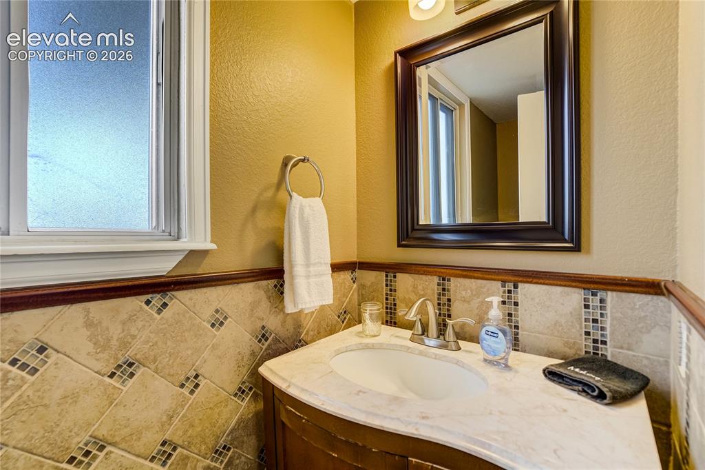 Image 15 of 40: Bathroom vanity with a white countertop and integrated sink, brushed nickel