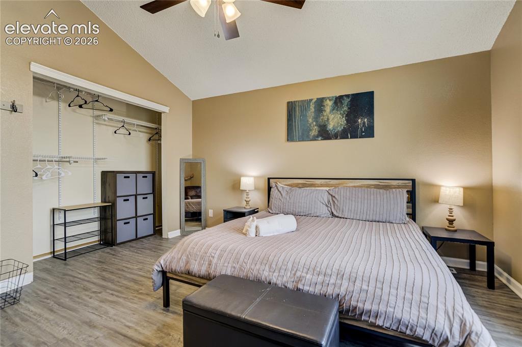 Image 18 of 40: Room featuring wood-finish flooring, vaulted ceilings, a ceiling fan, and a