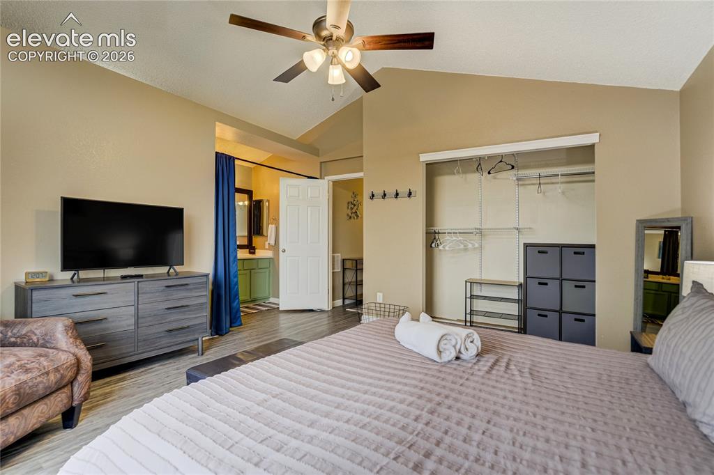 Image 19 of 40: Vaulted ceiling room featuring wood-finish flooring, a ceiling fan with int