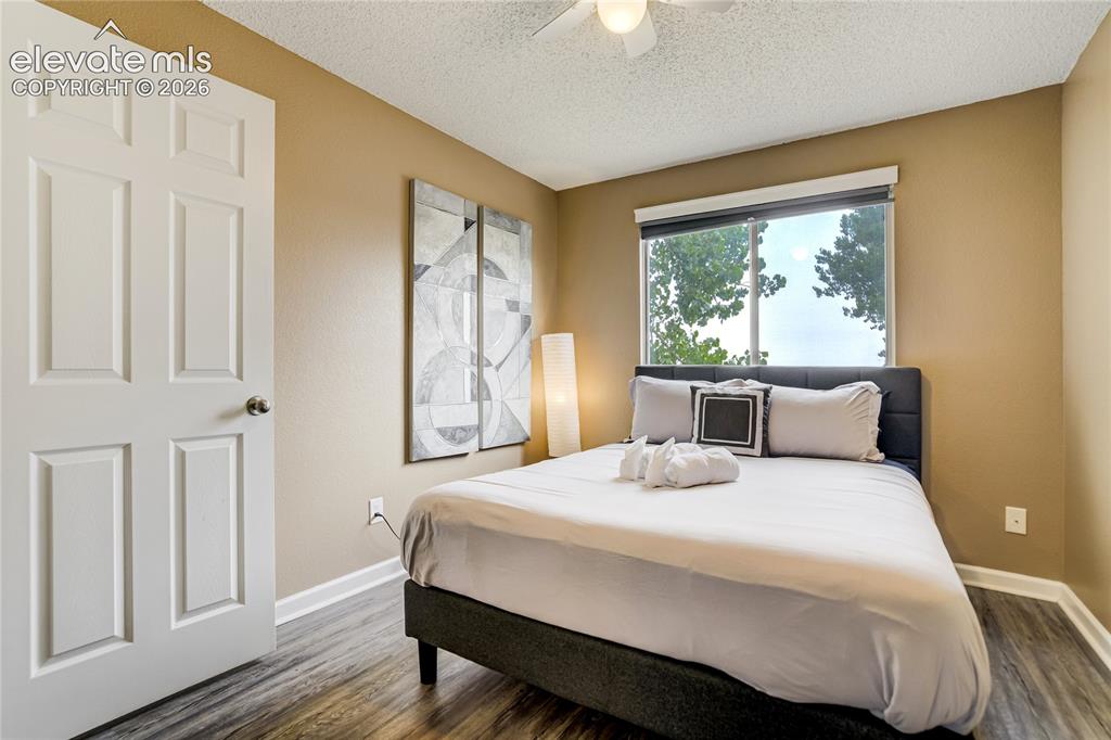 Image 23 of 40: Bedroom featuring wood-finish flooring, a six-panel door, and a window with