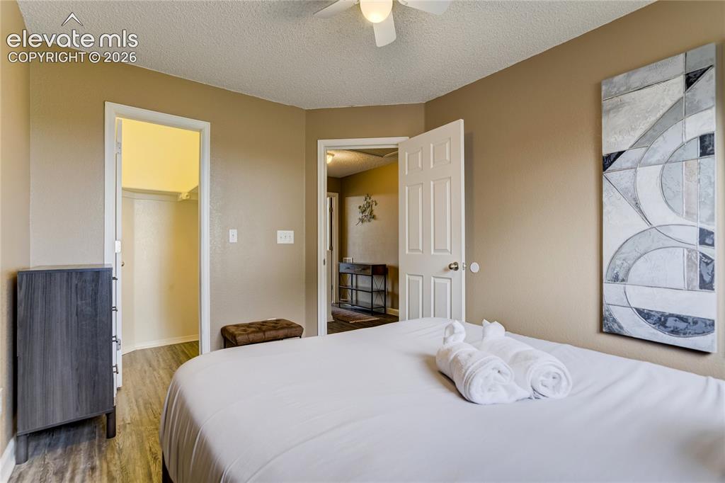 Image 24 of 40: Bedroom featuring neutral wall paint, wood-finish flooring, a ceiling fan,
