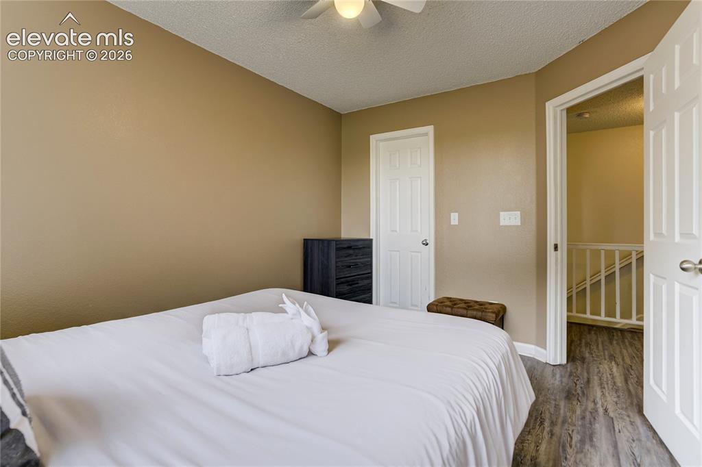 Image 25 of 40: Bedroom featuring neutral wall tones, wood-finish flooring, a ceiling fan,
