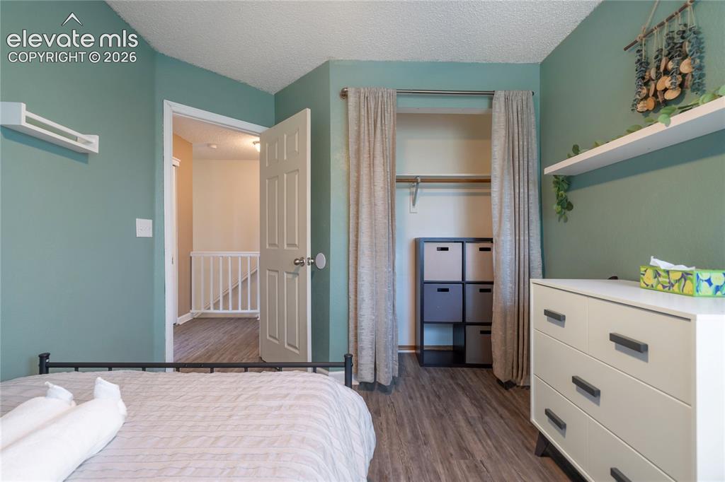Image 28 of 40: Interior room featuring wood-finish flooring, a built-in closet with draper