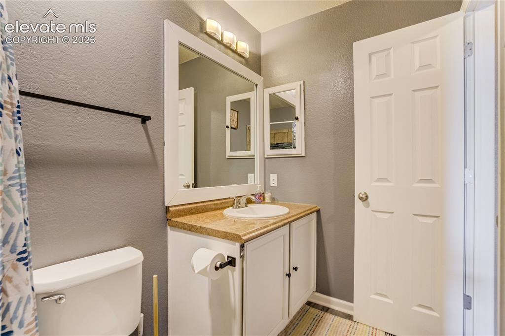 Image 30 of 40: Bathroom featuring a single vanity with a white basin, light-toned countert