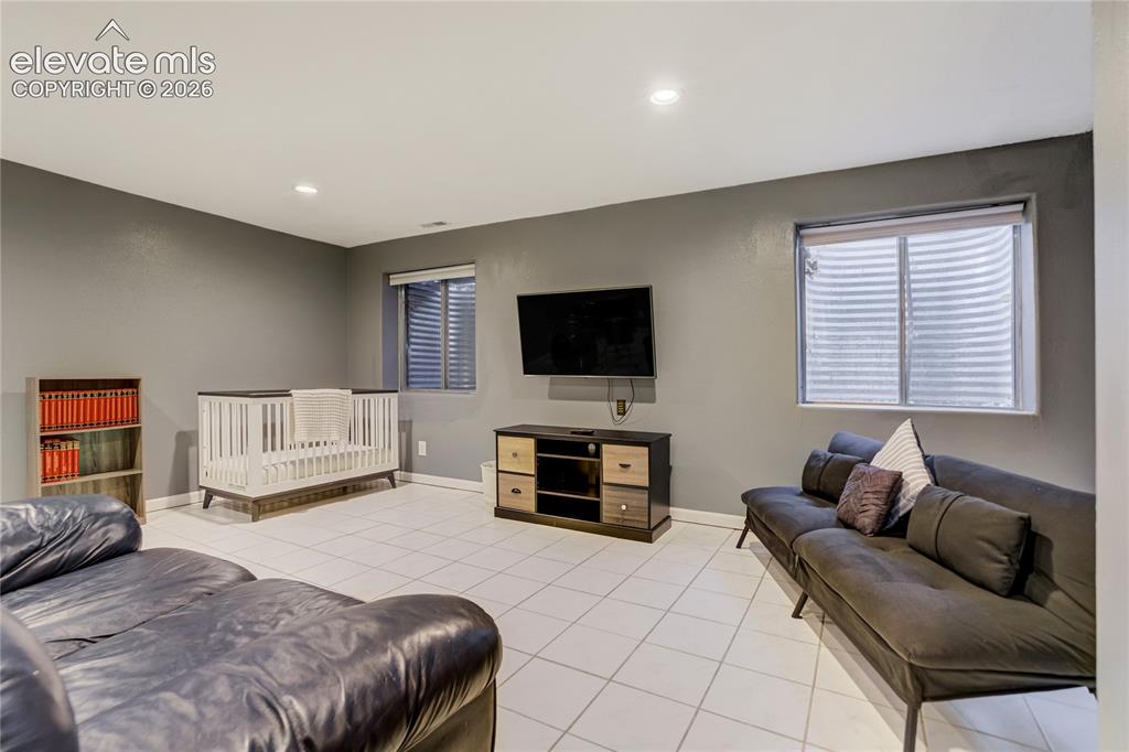Image 31 of 40: Spacious room featuring light-colored tile flooring and recessed lighting