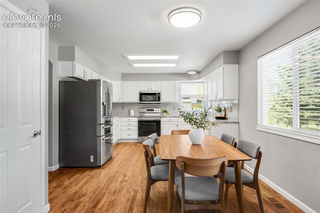 Image 13 of 36: Kitchen featuring white cabinetry, stainless steel appliances, wood-finish