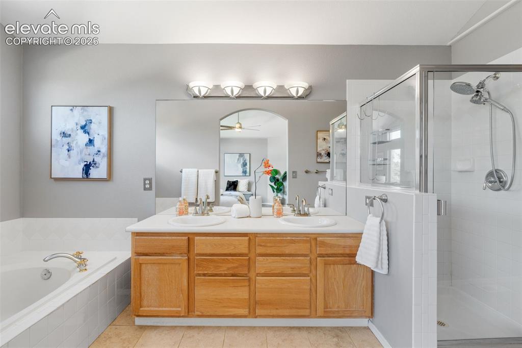 Image 21 of 36: Double vanity with a composite countertop, drop-in sinks, wooden cabinetry,
