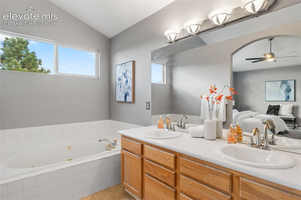 Image 22 of 36: Bathroom featuring a dual-sink vanity with light-tone wood cabinetry, a jet