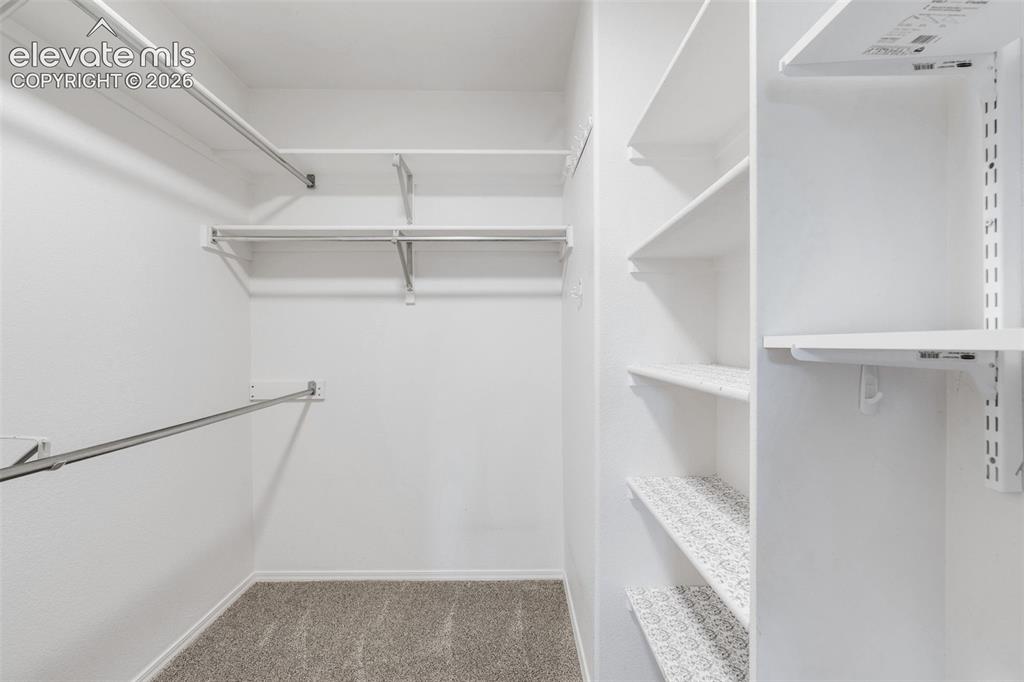 Image 27 of 36: Storage space featuring multi-level wire shelving, dedicated hanging rods, 