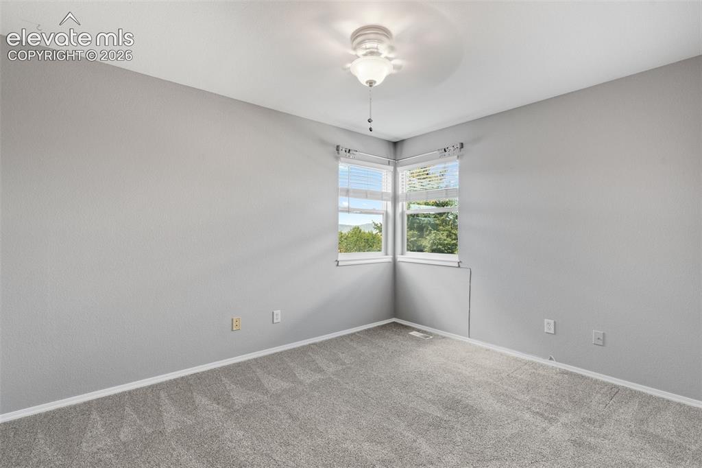 Image 28 of 36: Neutral wall tones, wall-to-wall carpeting, ceiling-mounted light fixture w
