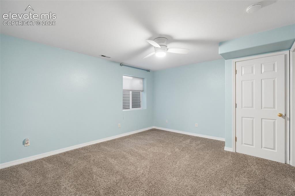 Image 30 of 36: Neutral-toned wall-to-wall carpeting, white six-panel interior door, ceilin
