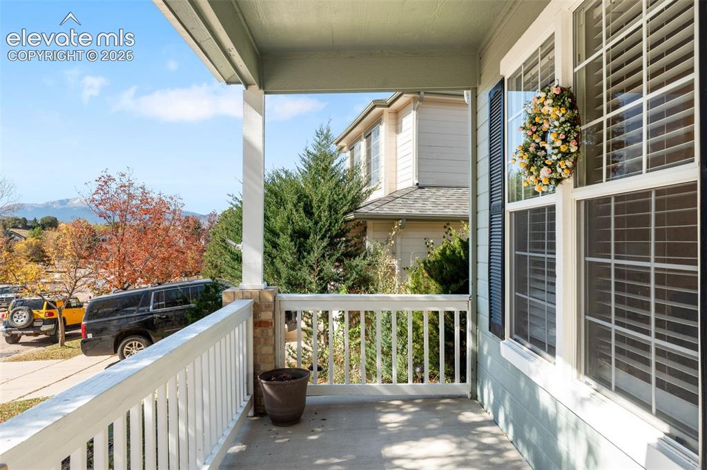 Image 4 of 36: Covered porch featuring concrete flooring, white wooden railing, column wit