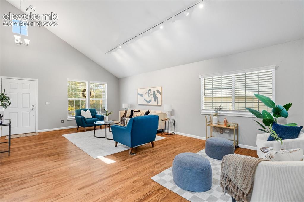 Image 8 of 36: Vaulted ceilings featuring recessed track lighting, wood-finish flooring, a