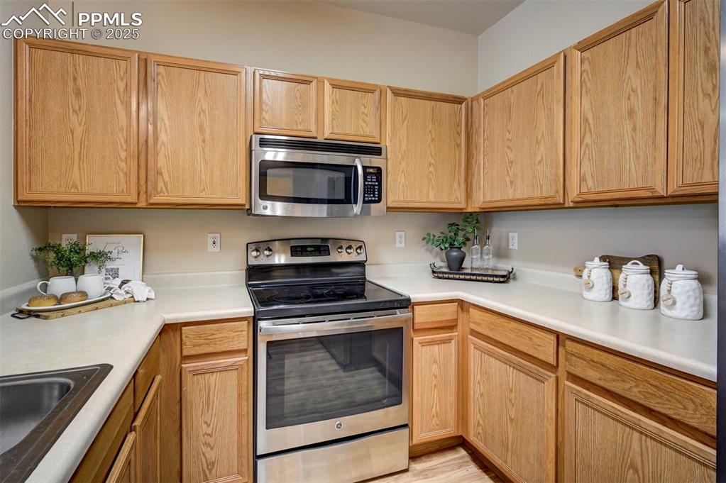 Image 10 of 26: Kitchen featuring appliances with stainless steel finishes, a sink, light c