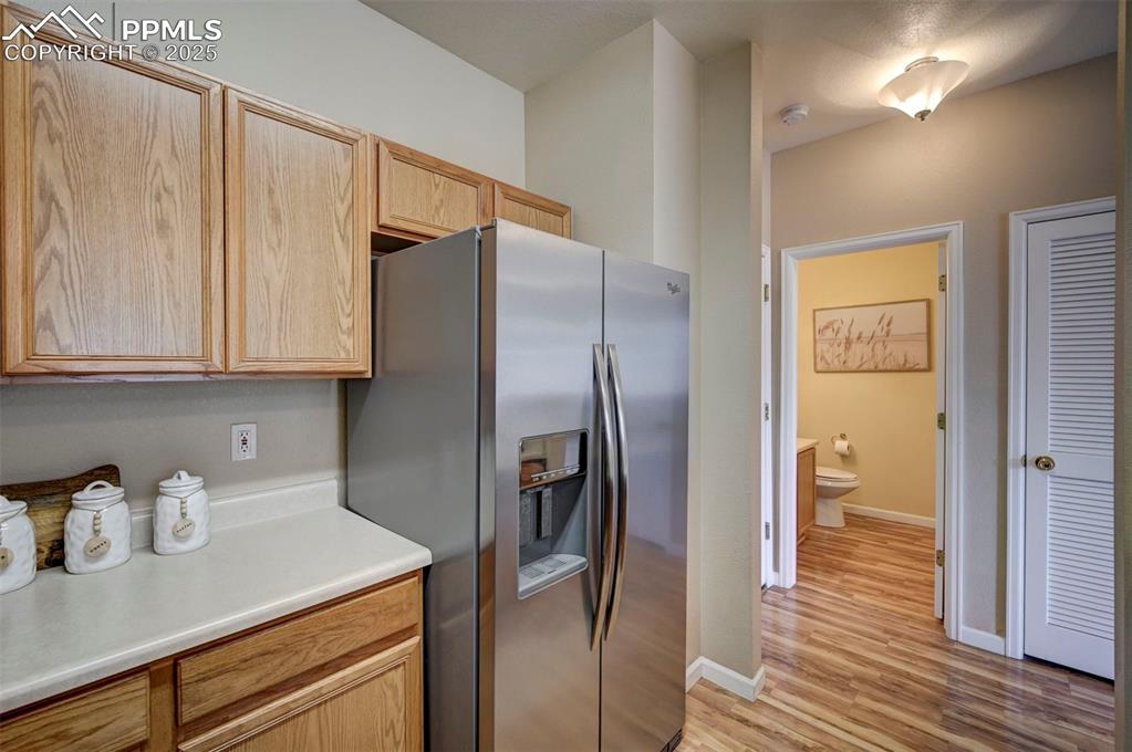 Image 12 of 26: Kitchen with stainless steel fridge with ice dispenser, light brown cabinet