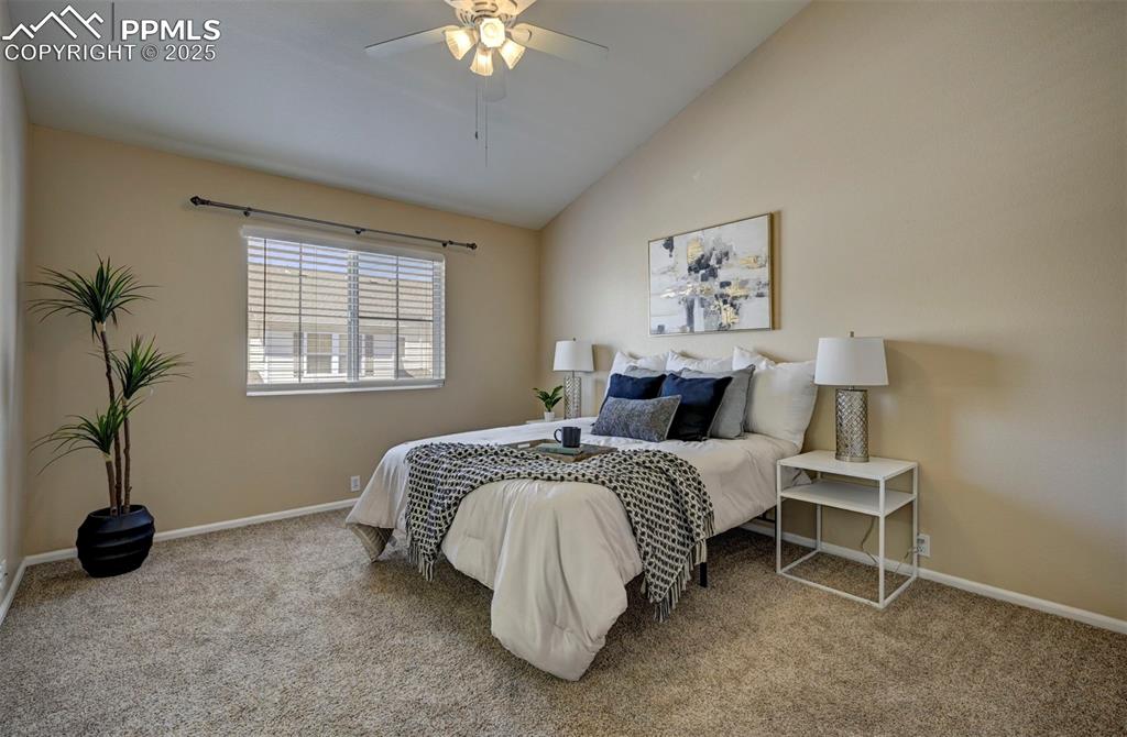 Image 14 of 26: Bedroom with carpet, vaulted ceiling, baseboards, and ceiling fan