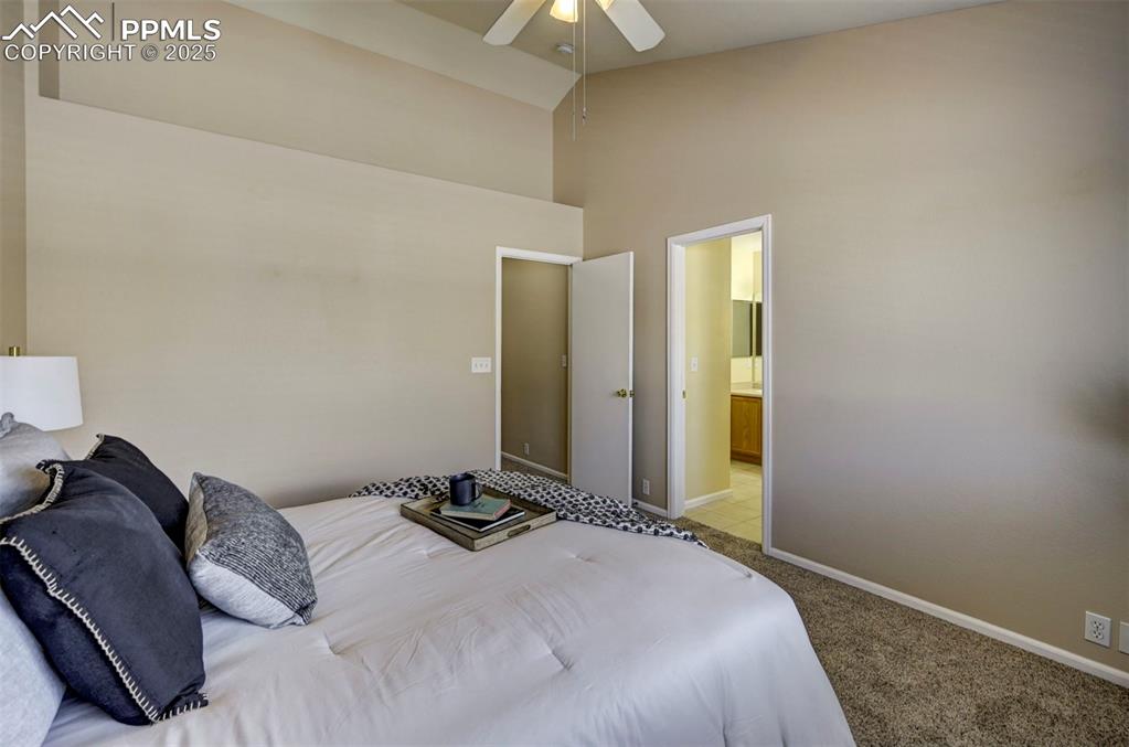 Image 15 of 26: Bedroom with a high ceiling, carpet flooring, baseboards, a ceiling fan, an