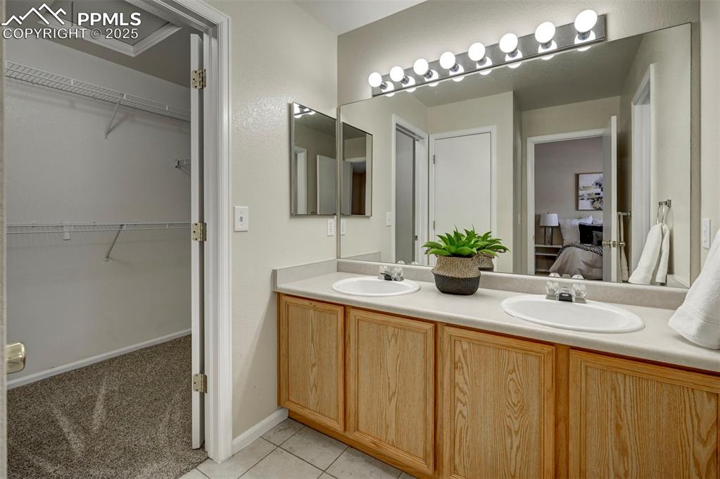 Image 17 of 26: Bathroom with double vanity, ensuite bath, tile patterned flooring, and a w