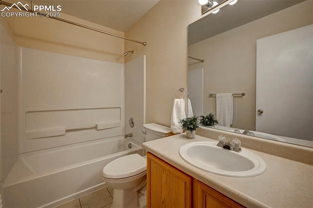 Image 20 of 26: Full bath featuring toilet, tile patterned flooring, shower / bath combinat
