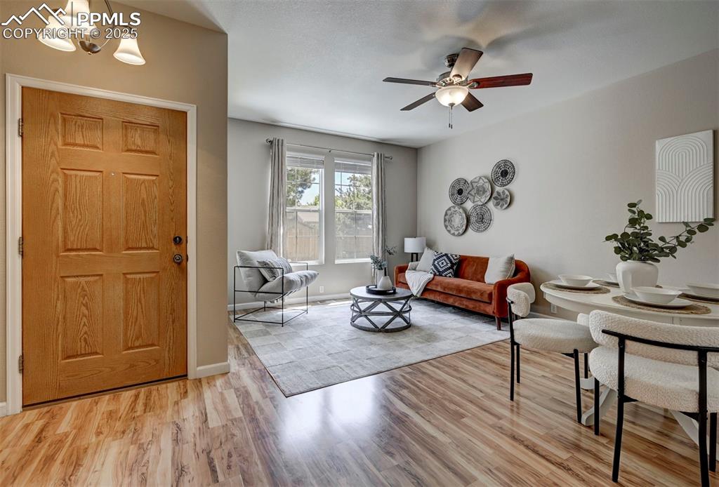 Image 4 of 26: Living room featuring light wood-type flooring, a ceiling fan, and baseboar