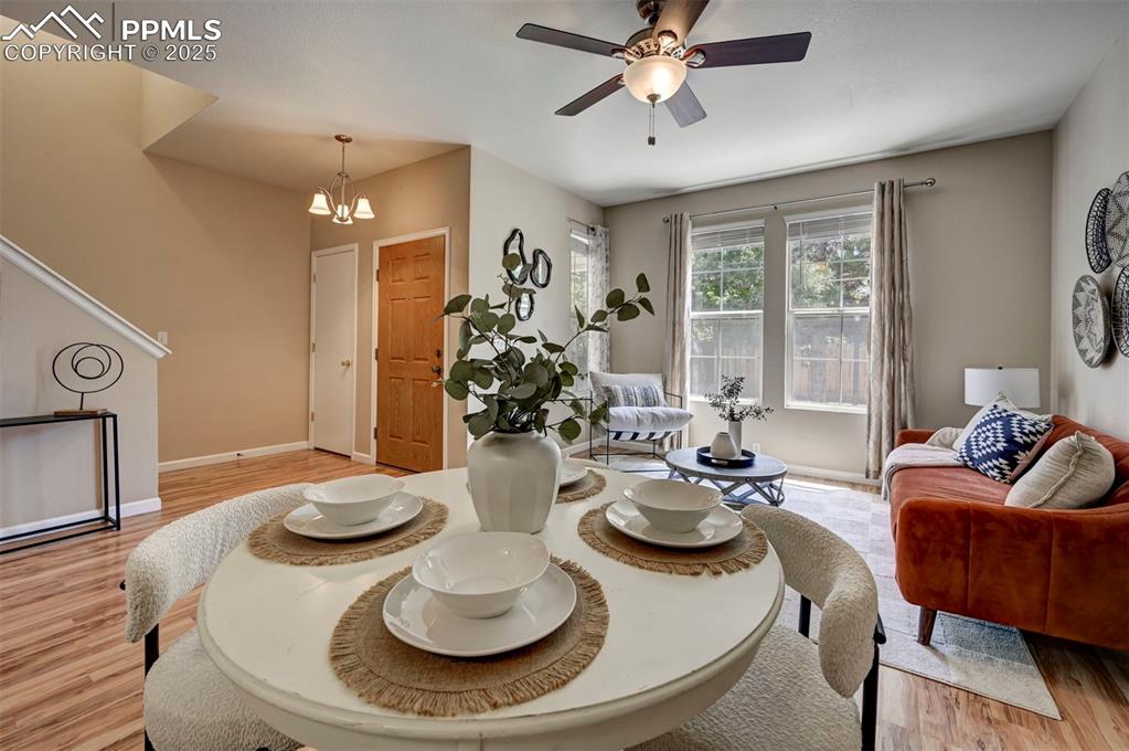 Image 5 of 26: Living area with a ceiling fan, light wood finished floors, a chandelier, a