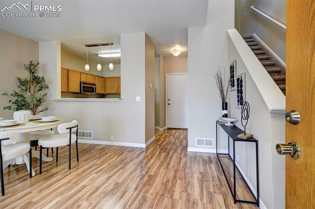 Image 6 of 26: Entryway featuring light wood-style floors, stairway, and baseboards