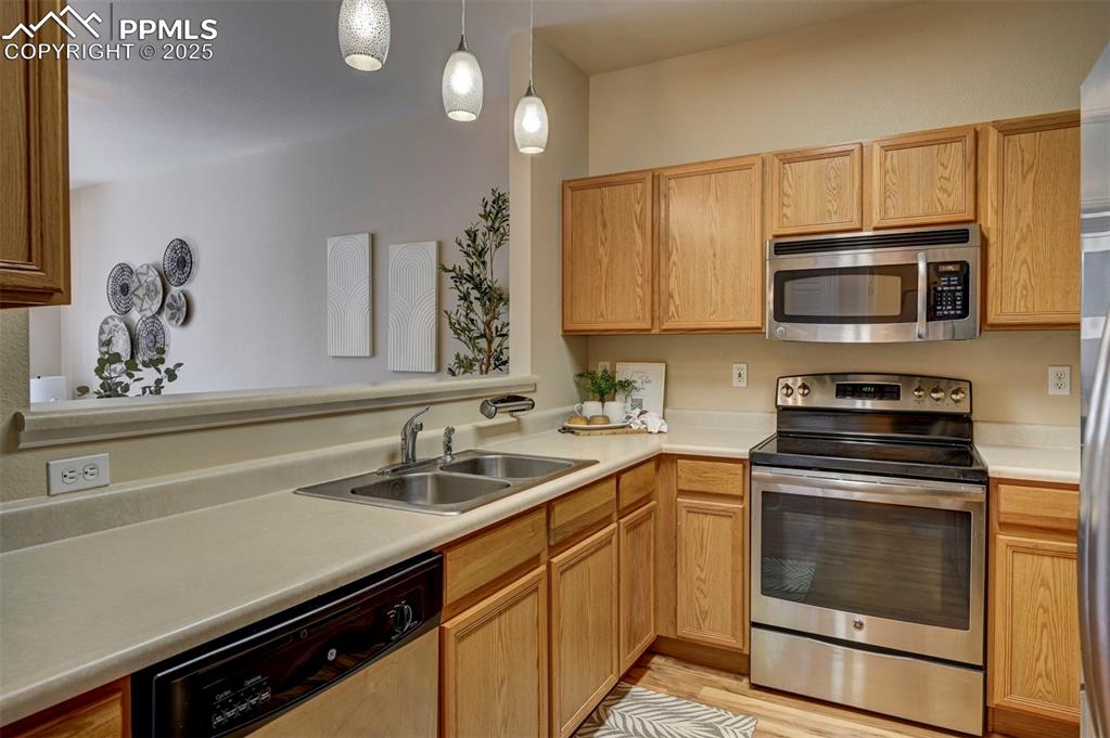 Image 9 of 26: Kitchen with stainless steel appliances, a sink, light countertops, and dec