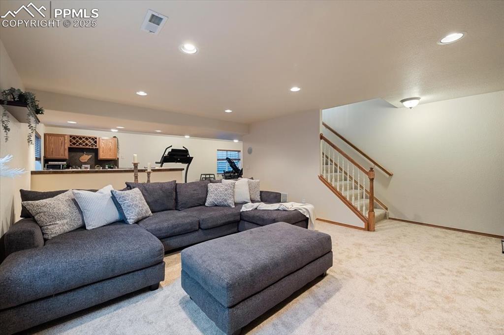 Image 38 of 50: Living room featuring baseboards, recessed lighting, stairs, visible vents,