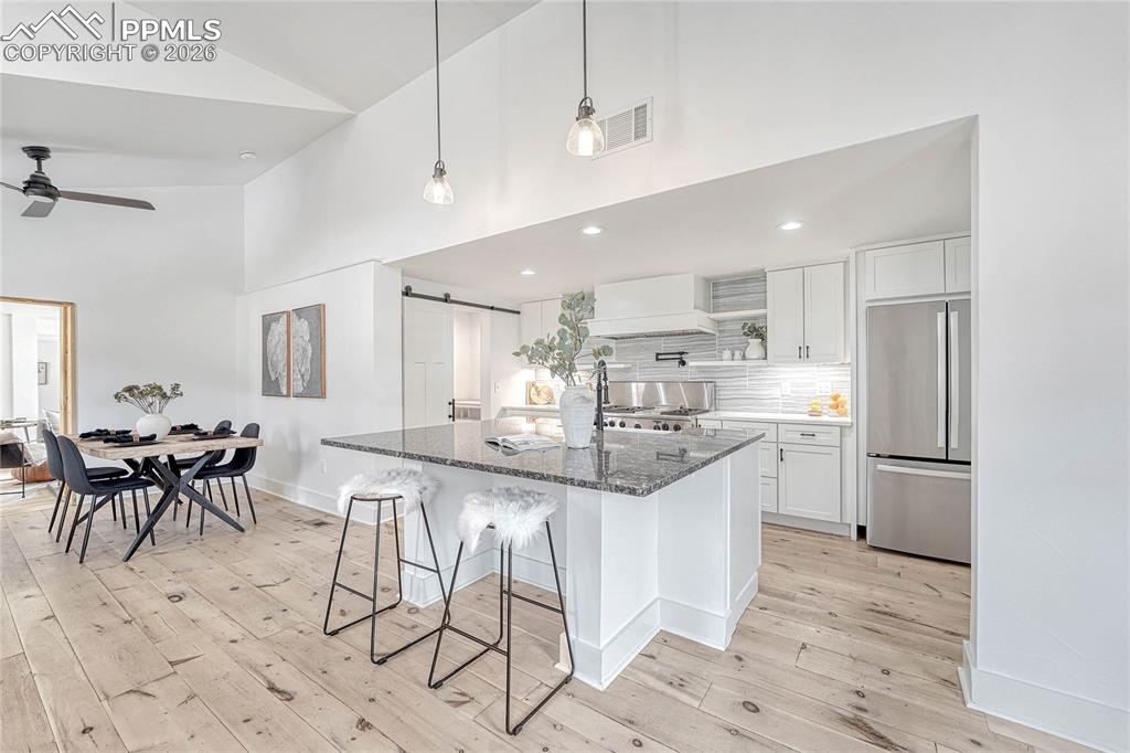 Image 10 of 45: Modern Kitchen, Wood Flooring, Refrigerator, Cabinets, Ceiling Fan