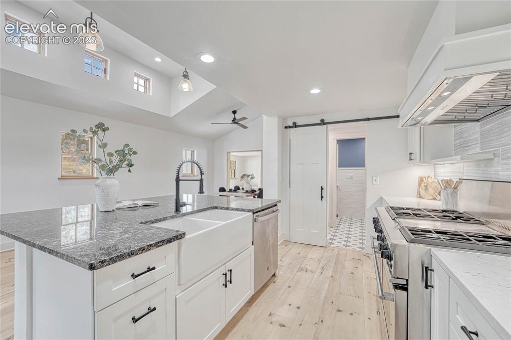 Image 8 of 45: Modern Kitchen, Wood Flooring, Refrigerator, Cabinets, Ceiling Fan